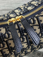 Dior Oblique zip pocket detail with navy leather tab and gold zipper, close-up