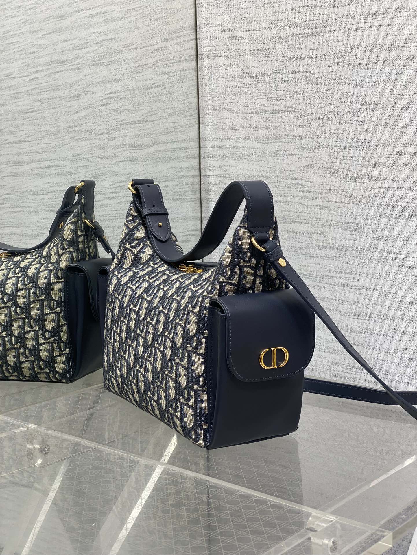 Dior Oblique handbags with navy leather accents, featuring gold CD logo on one bag
