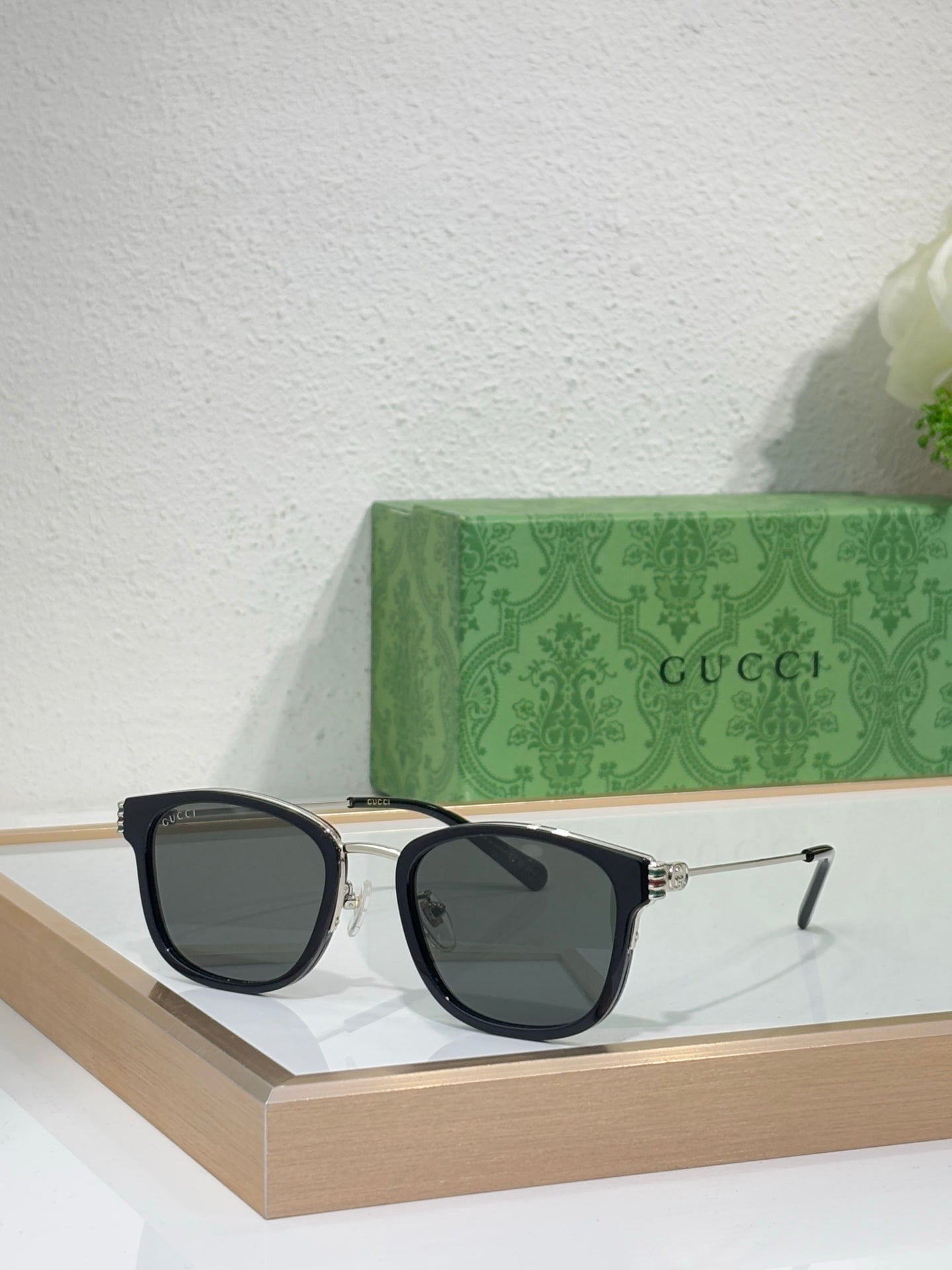 Glasses with black rectangular frames, gold accents, and dark gray lenses