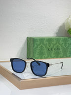 Glasses with dark blue lenses and black rectangular frames with gold accents