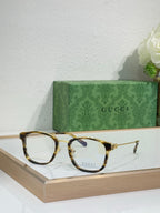 Glasses with tortoiseshell frames, gold accents, and clear lenses