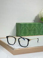Glasses with black frames, gold accents, and blue-tinted lenses