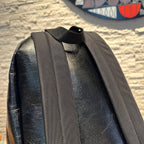Black leather backpack with wide webbing shoulder strap