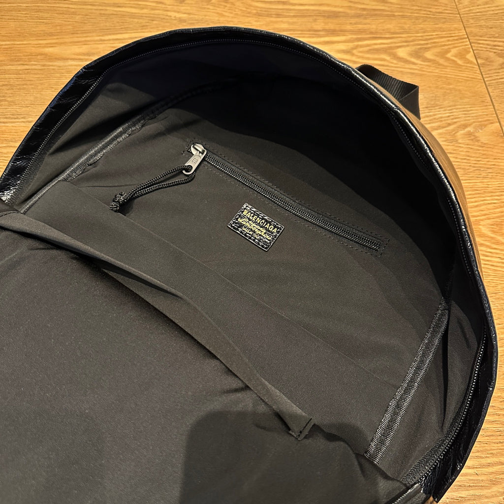 Black backpack interior with zip pocket and small logo patch
