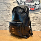 Black leather backpack with front flap pouch and drawstring tie cords