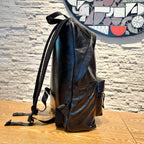 Black leather backpack with tall back panel and side pocket, rear view