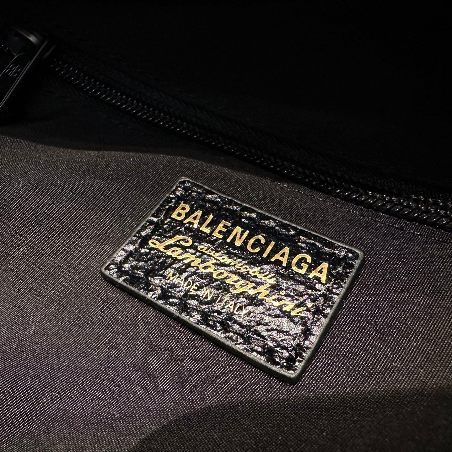 Balenciaga logo label on black interior fabric near zipper
