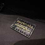 Black interior fabric label with BALENCIAGA branding and graphic