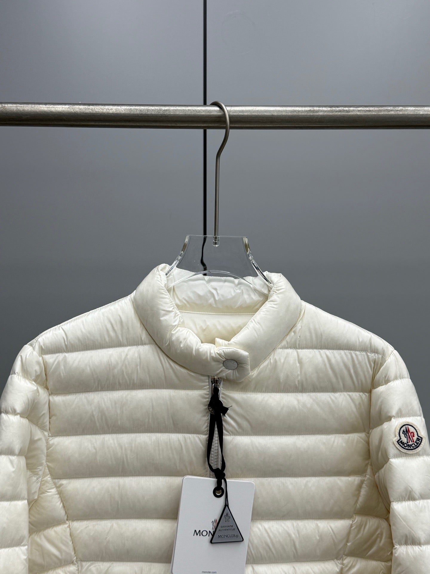 Moncler light puffer jacket with hood, front zipper, small circular logo patch on sleeve