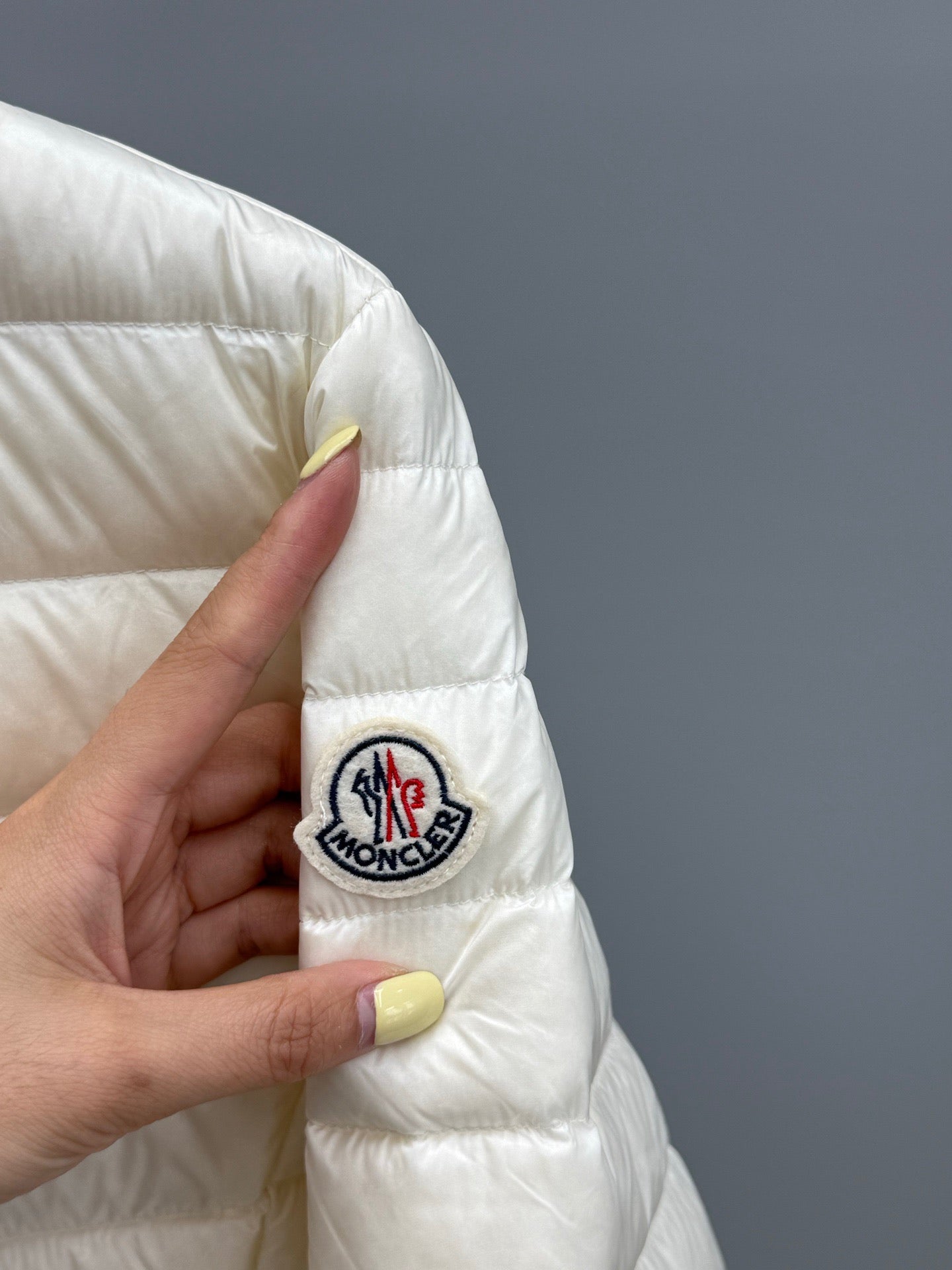 Moncler light puffer jacket sleeve patch with circular logo, quilted fabric detail