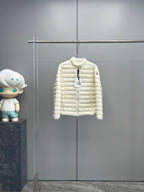 Moncler hooded puffer jacket in light color, front zip closure, hanging on a rack