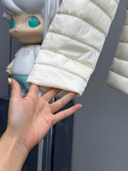 Moncler light puffer jacket hem and sleeve, quilted layers, held in a hand