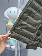 Dark green puffer jacket sleeve with elastic cuff and stitched quilting.