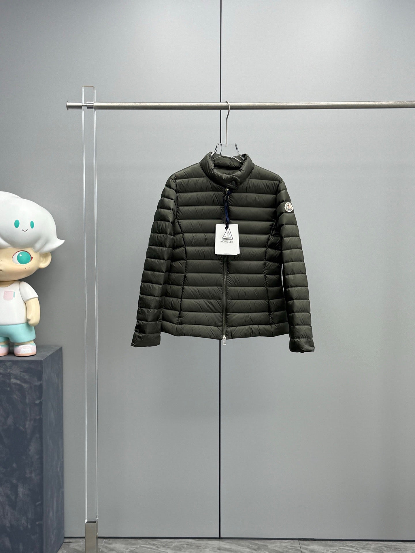 Dark puffer jacket with full zipper and stand collar.