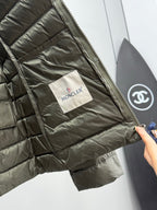 Olive puffer jacket interior with Moncler fabric tag and side seam pocket.