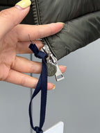 Puffer jacket zipper with blue fabric pull tab and metal puller.