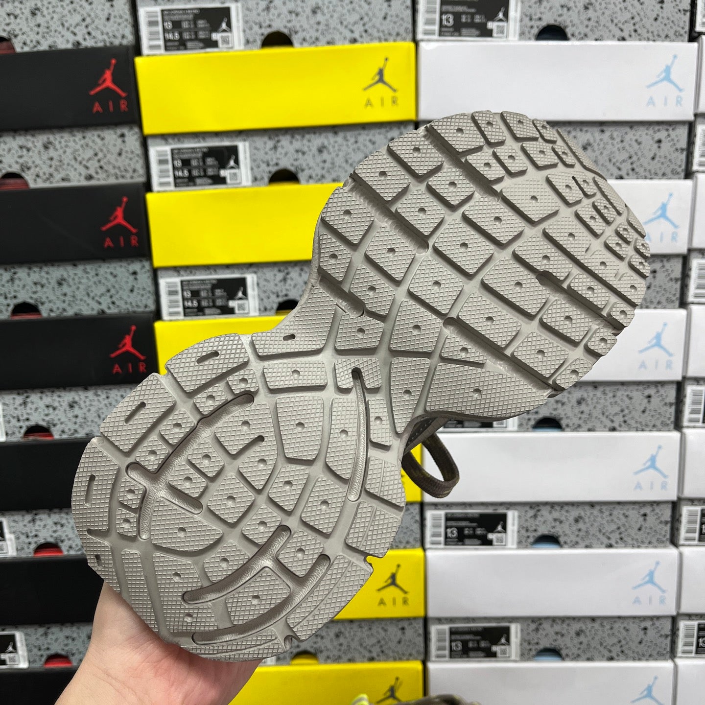Gray sneaker outsole with deep tread and small grip patterns