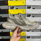 Silver gray sneaker side view with neon yellow accents and chunky shock-absorb sole