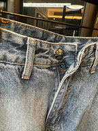 Light blue denim pants with belt loops and ornate button fly front