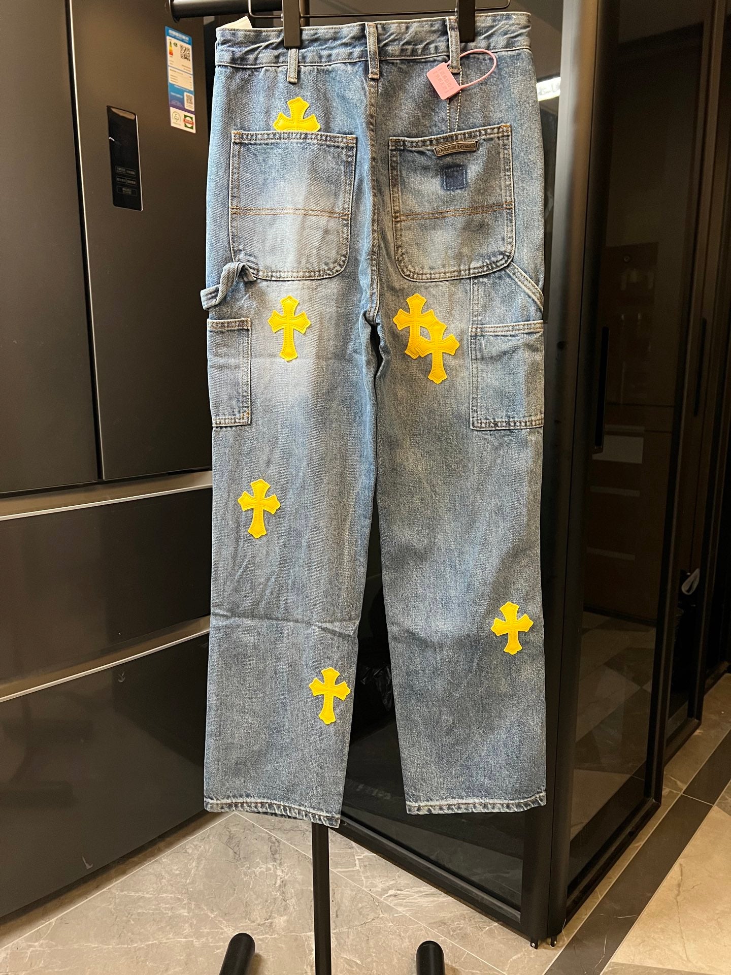 Light blue denim pants with yellow cross embroidery and back pocket patches