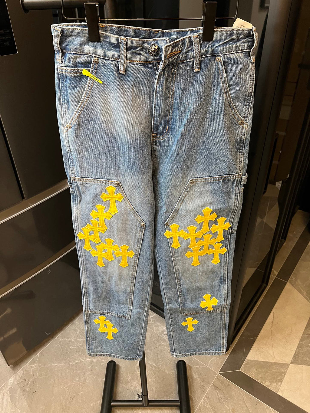 Light blue denim pants with yellow cross embroidery and front seam details