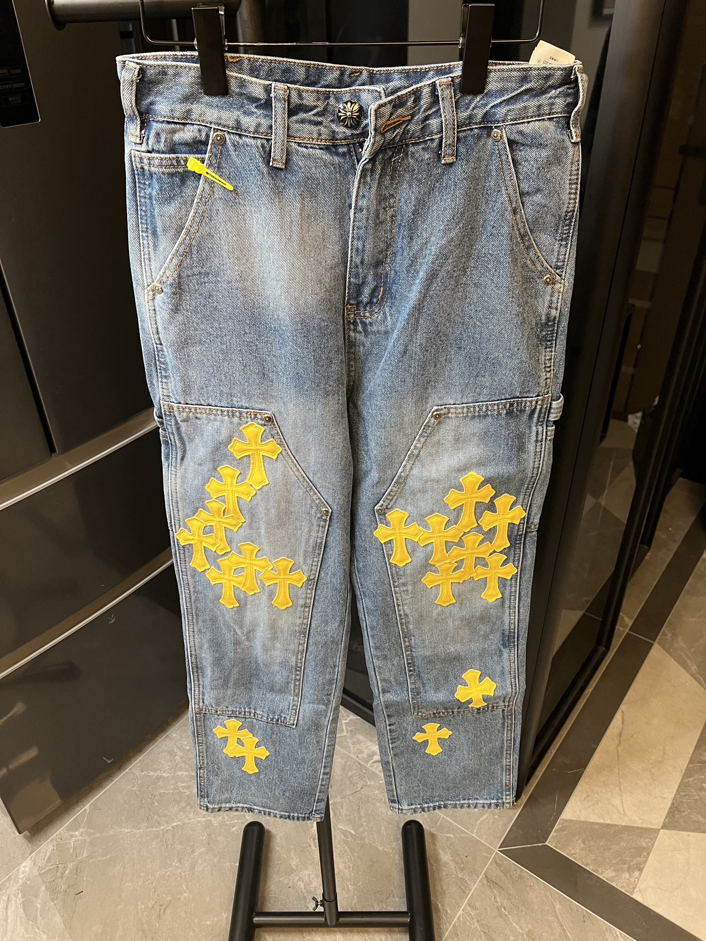 Light blue denim pants with yellow cross embroidery and front seam details