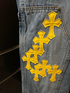 Light blue denim pants with large yellow cross patch on the pocket