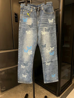 Light blue denim pants with butterfly patches, front zipper, and belt loops