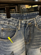 Light blue denim jeans with front fly, belt loops, and black butterfly embroidery detail