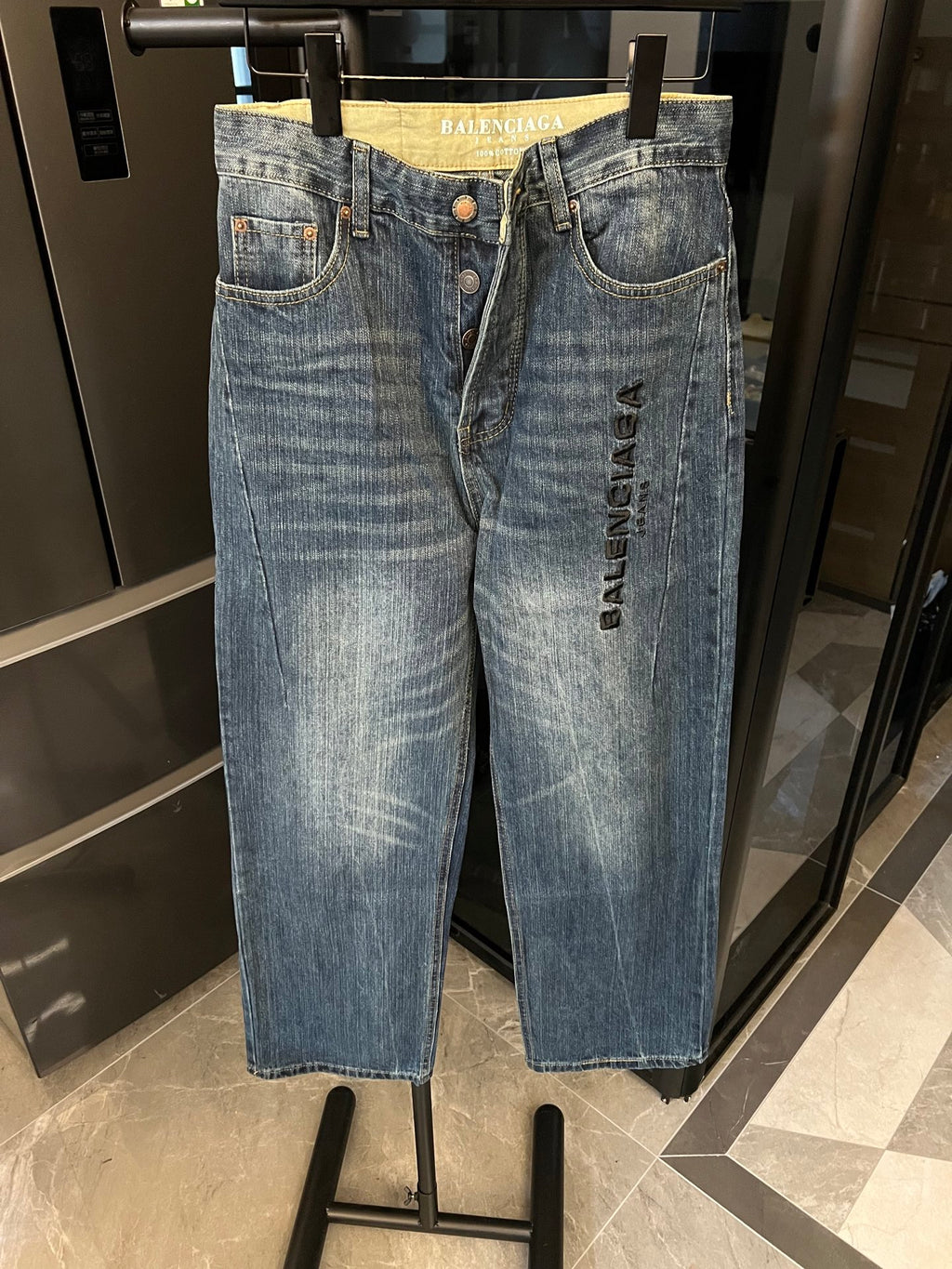 Denim jeans, light blue distressed wash, high-rise waistband, button closure, embroidered logo