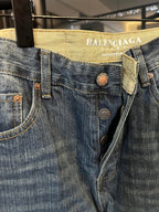 Denim jeans close-up, blue denim waistband with Balenciaga Jeans label and button details