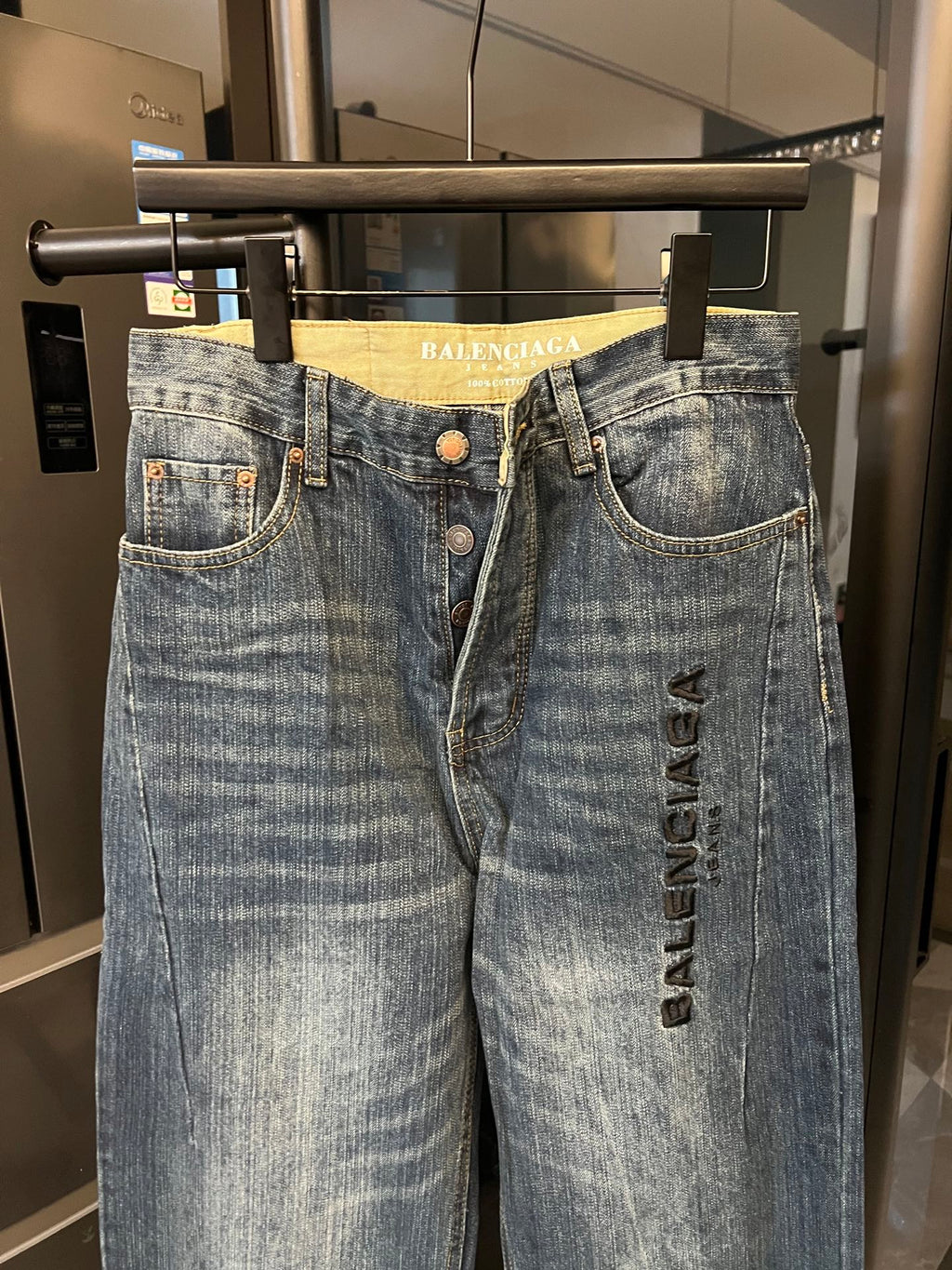 Denim jeans, light blue wash, high-rise waist, belt loops, front button, logo print