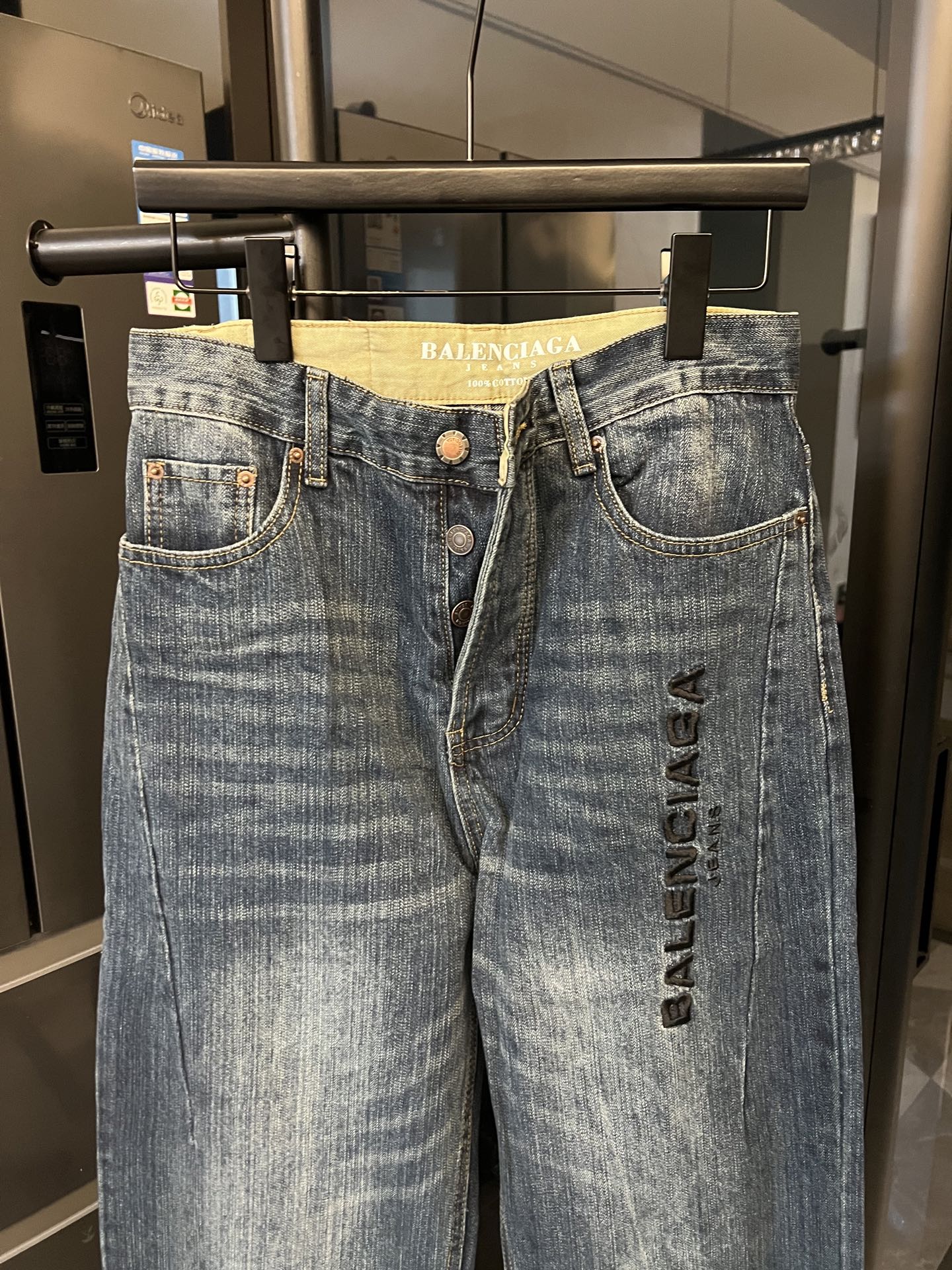 Denim jeans, light blue wash, high-rise waist, belt loops, front button, logo print