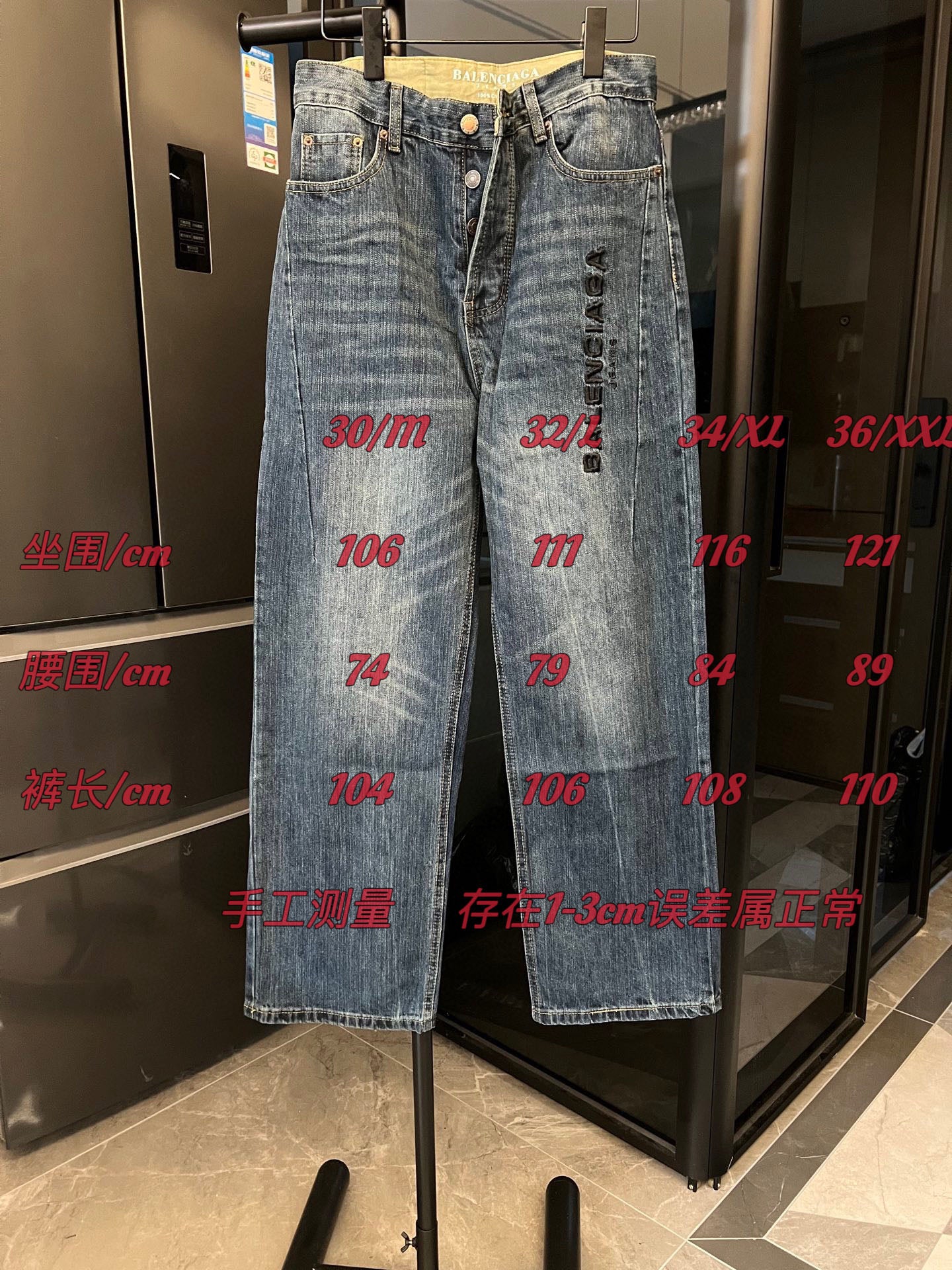 Denim jeans on display, light blue wash, button front and vertical logo detail