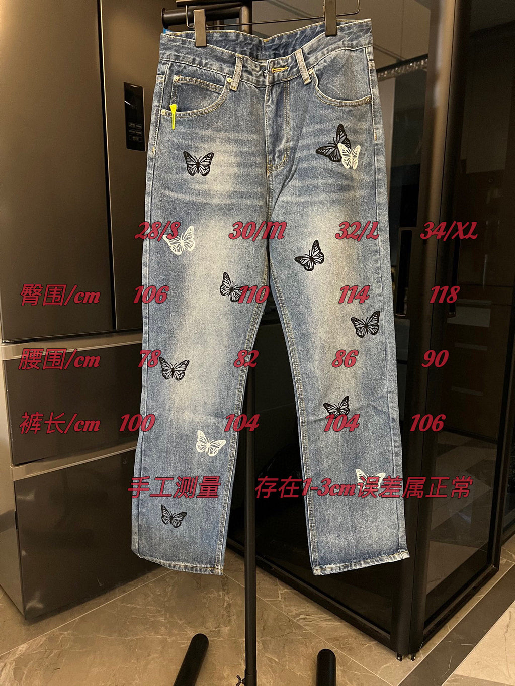 Light wash denim jeans with butterfly patches, with size measurements text overlay