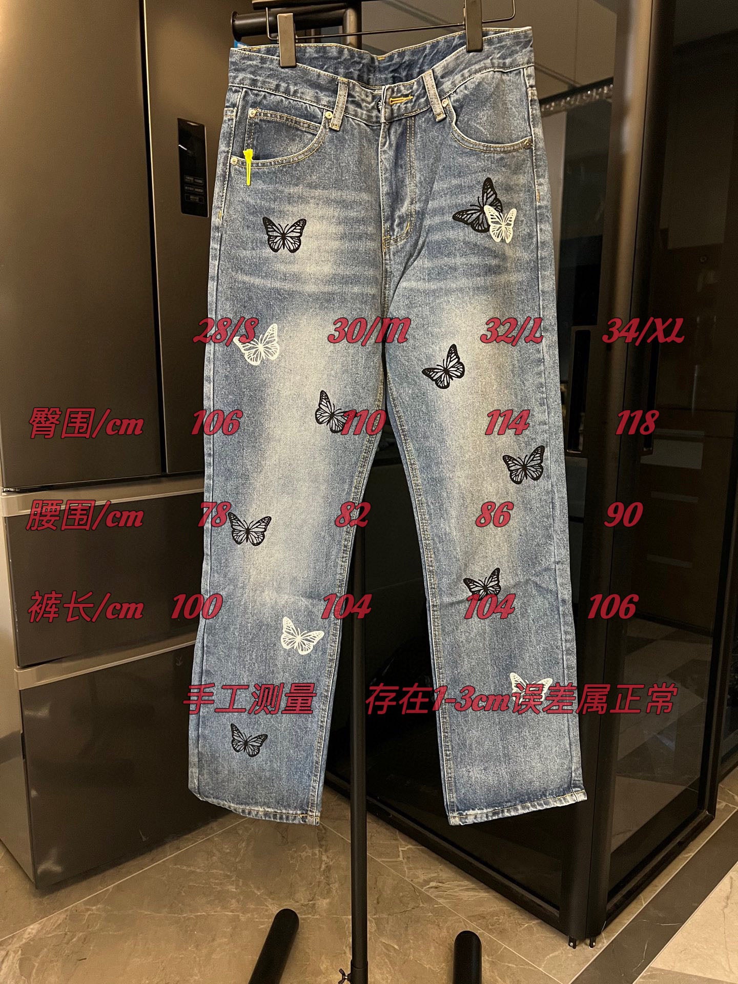 Light wash denim jeans with butterfly patches, with size measurements text overlay