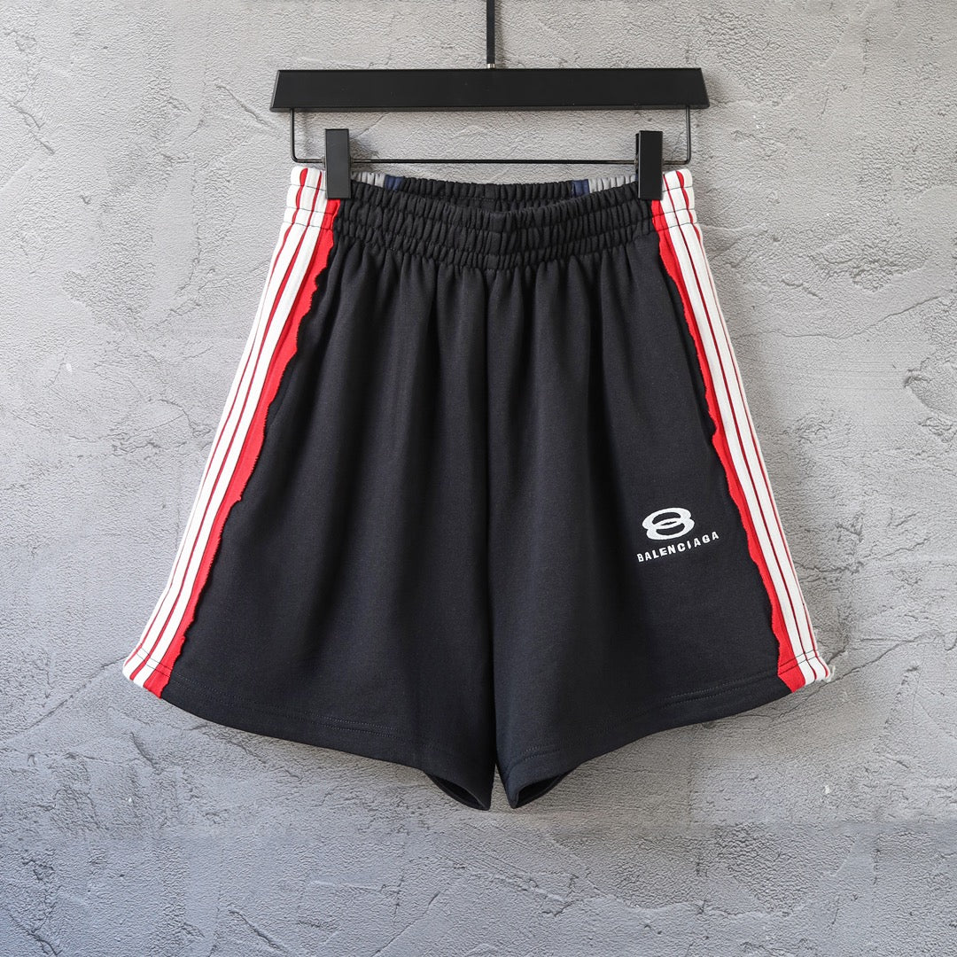 Black Balenciaga track shorts with red and white side stripes, elastic waistband