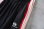 Black Balenciaga track shorts fabric with red, white, and blue side stripe trim