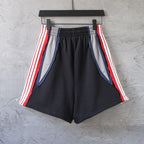 Black Balenciaga track shorts with red/white stripes and blue inner lining panels