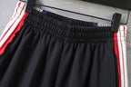 Black Balenciaga track shorts with red/white stripe trim and ruched waistband