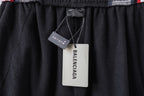 Black track pants with elastic waistband and hanging Balenciaga product tags