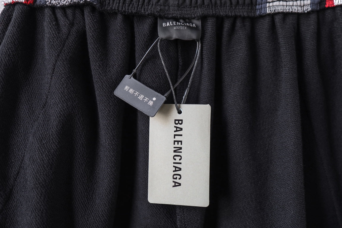 Black track pants with elastic waistband and hanging Balenciaga product tags
