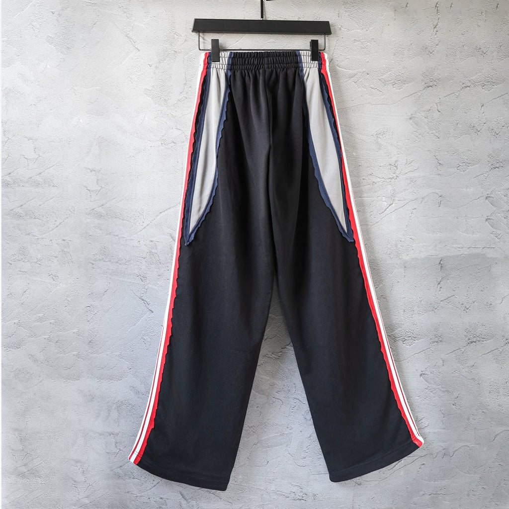 Black wide-leg track pants with red and white side stripes and gathered front