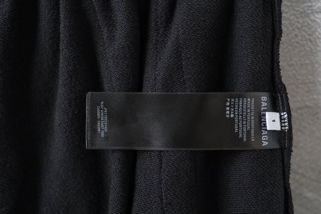 Black track pants with fabric care label and Balenciaga logo on inner waistband