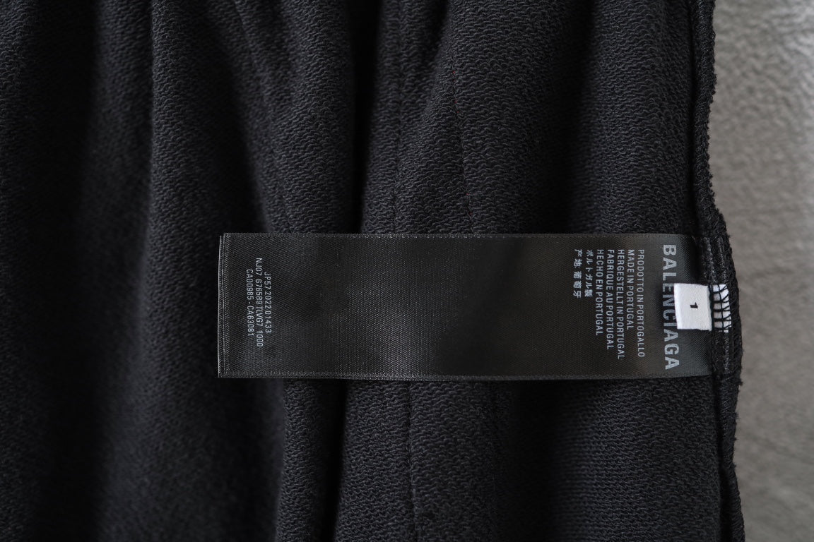 Black track pants with fabric care label and Balenciaga logo on inner waistband