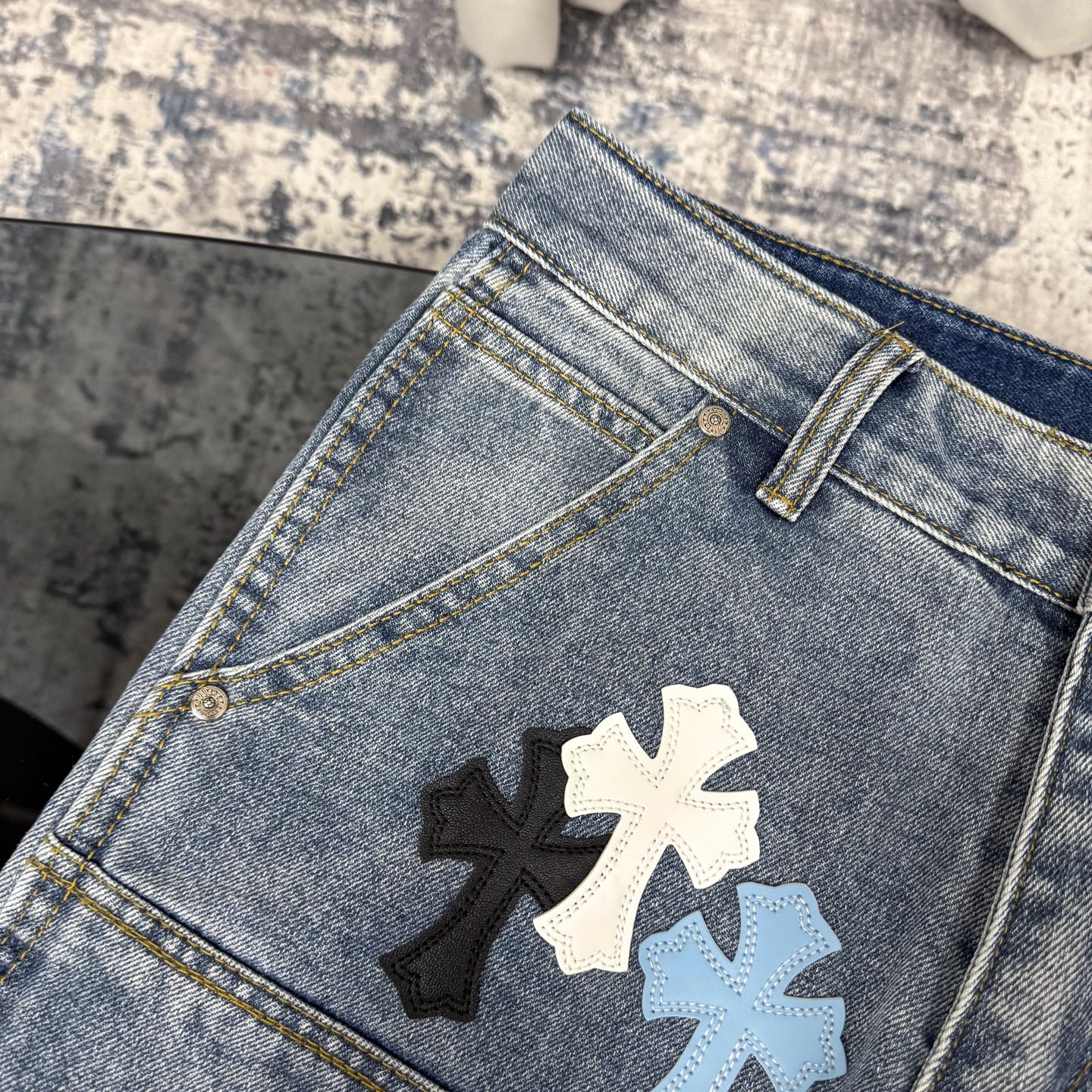 Light blue denim pants with cross applique on front pocket area