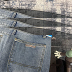 Light blue denim pants with logo label on pocket and cross applique accents