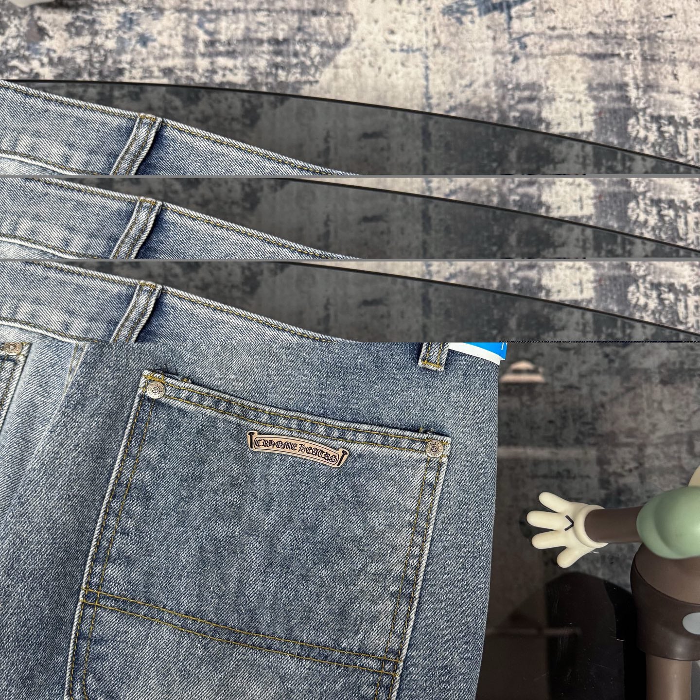 Light blue denim pants with logo label on pocket and cross applique accents