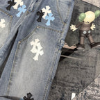 Light blue denim pants with cross applique patches across the legs