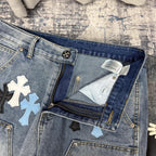 Light blue denim pants with inner pocket stitching and cross applique accents